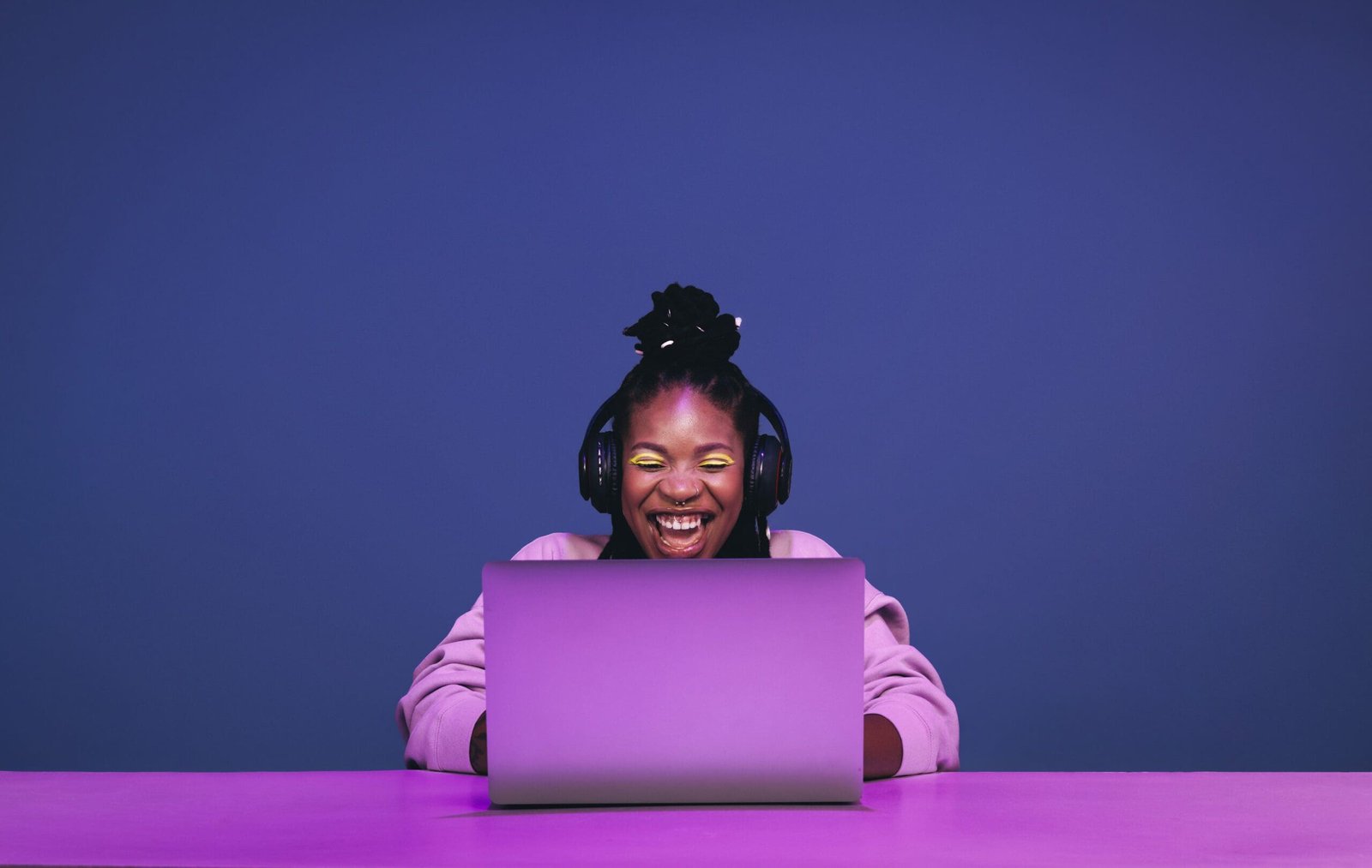 Cheerful female gamer winning an online game on a laptop